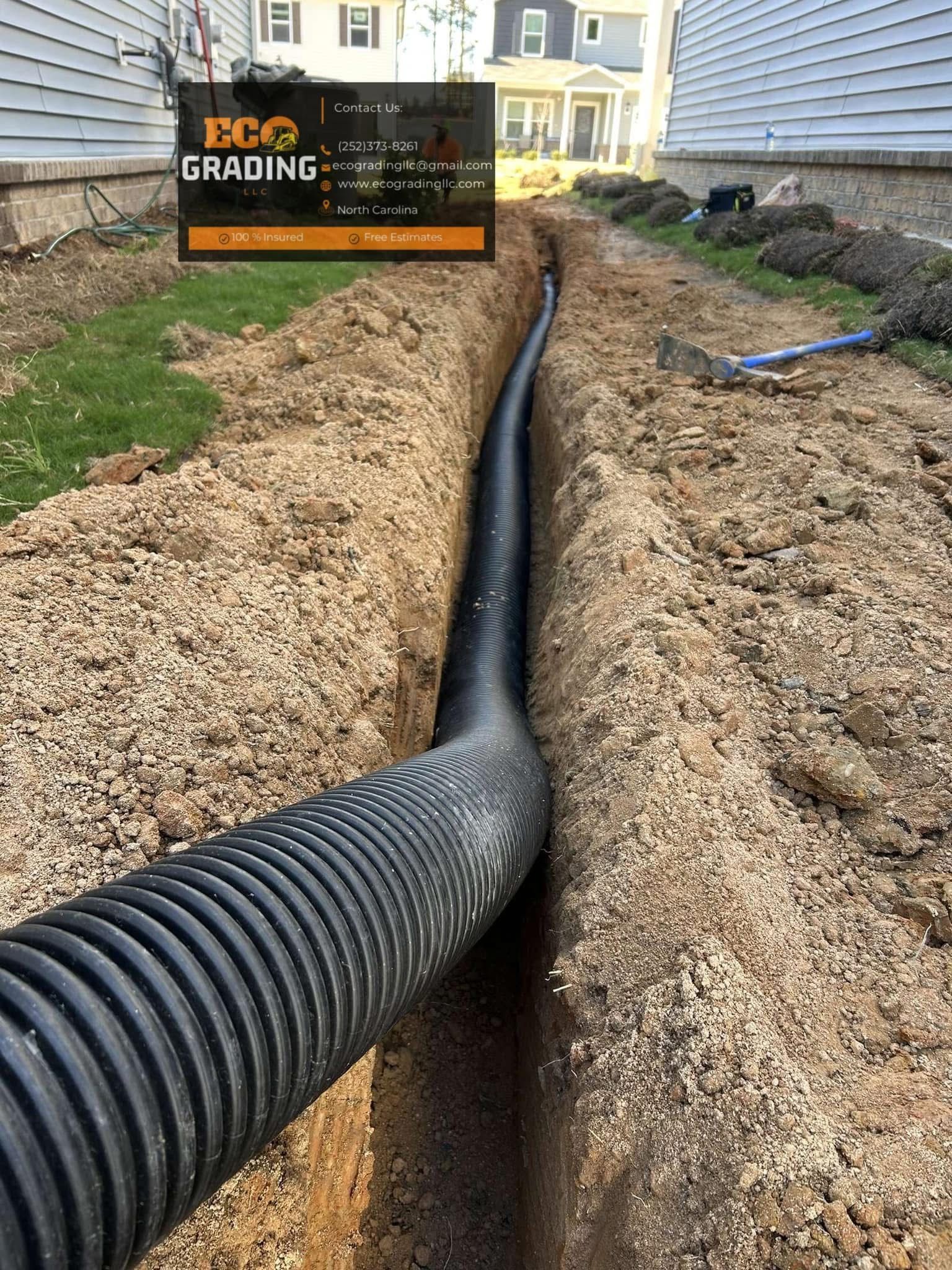 Black corrugated pipe in a trench, likely for drainage, surrounded by gravel and dirt.