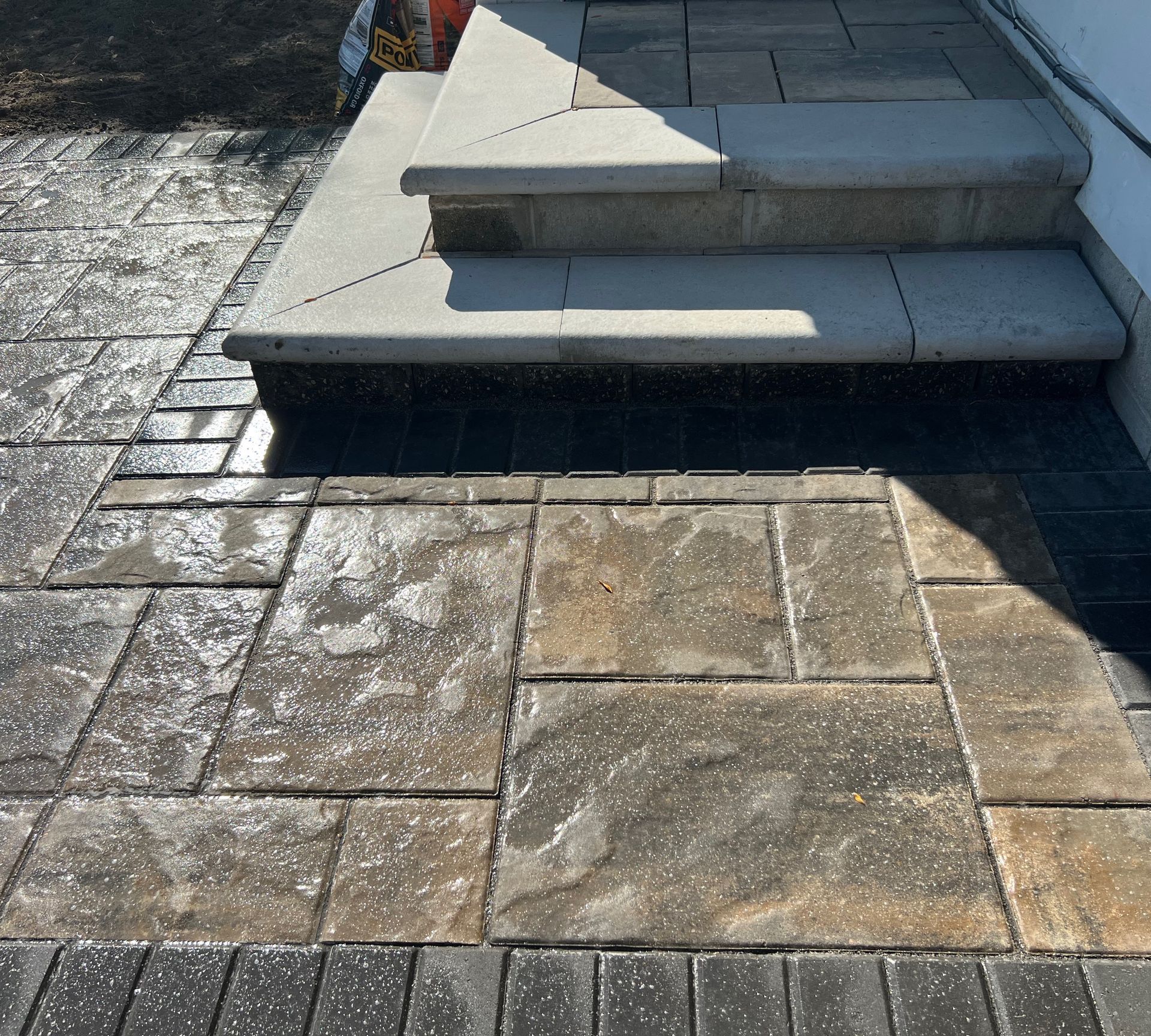 Stone steps leading to a front door with pavers and dark border.