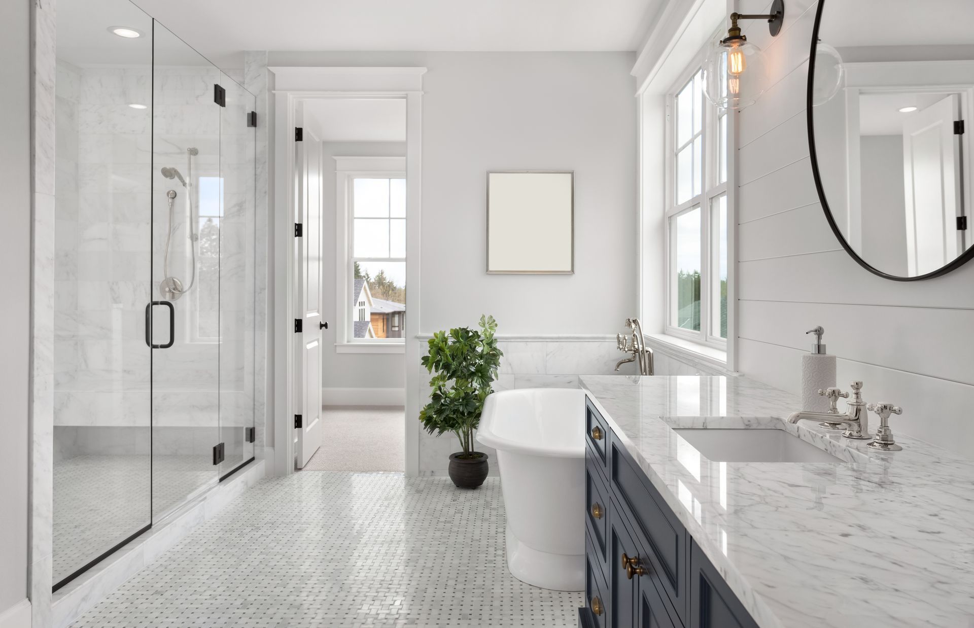 Modern bathroom featuring a glass shower, soaking tub, dark vanity with marble countertop, and marble mosaic floor tiles.