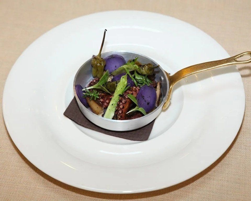 piatto con polpo e peperoncini verdi servito su padellina