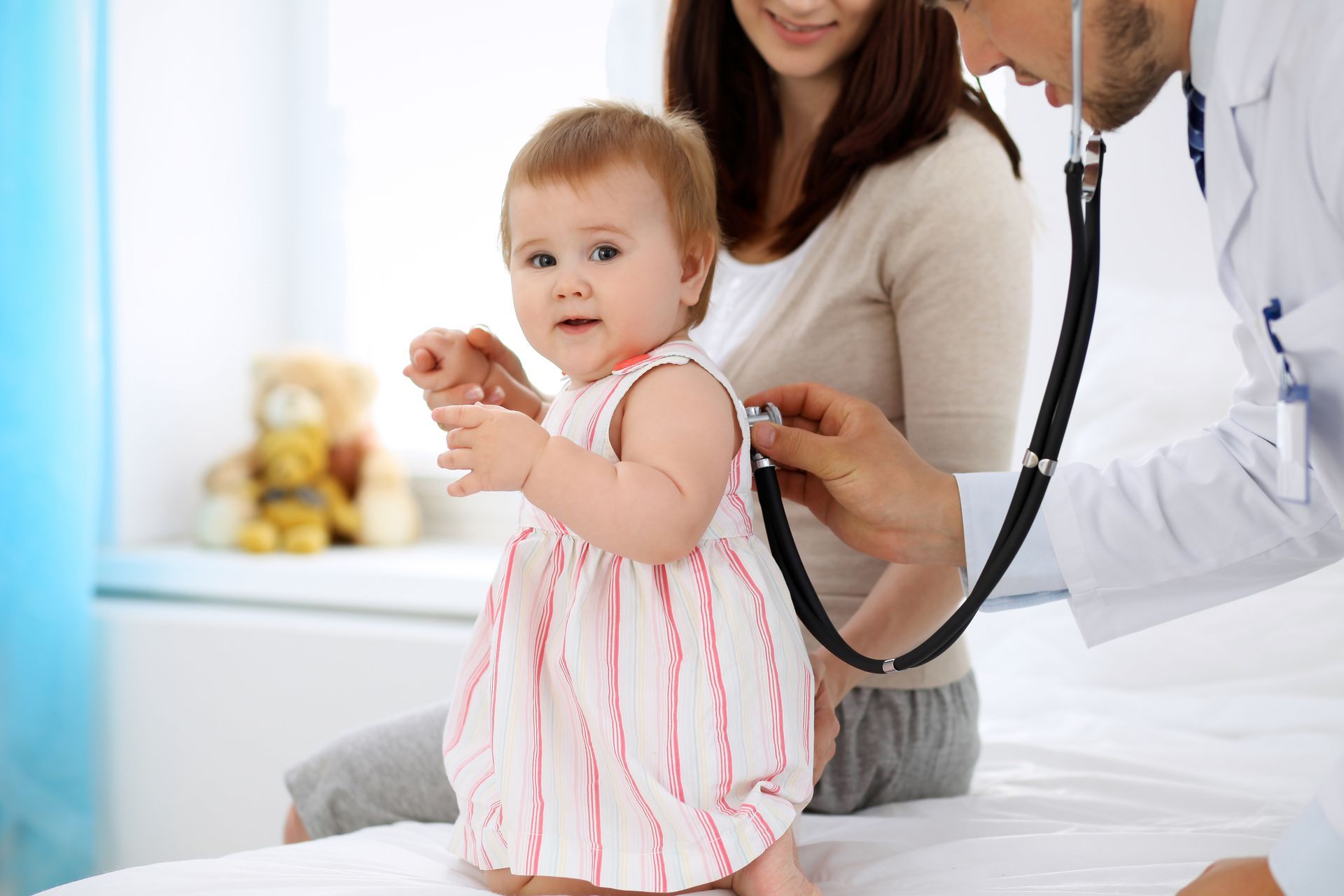 A baby is being examined by a doctor with a stethoscope.