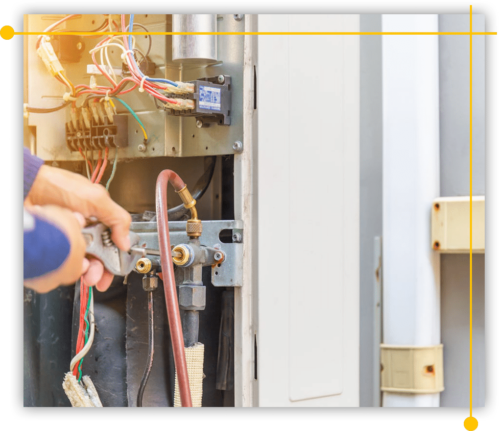 A person is working on an air conditioner with a wrench.
