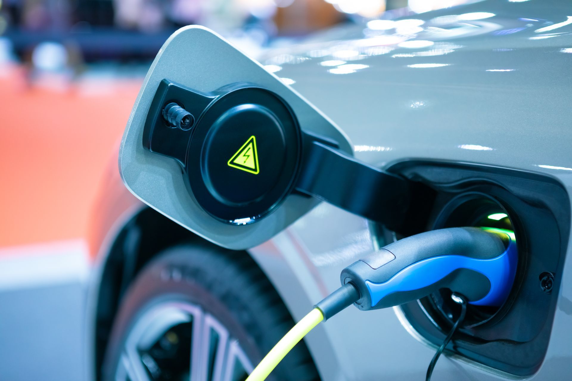 Electric vehicle charging with a cable plugged into the car.