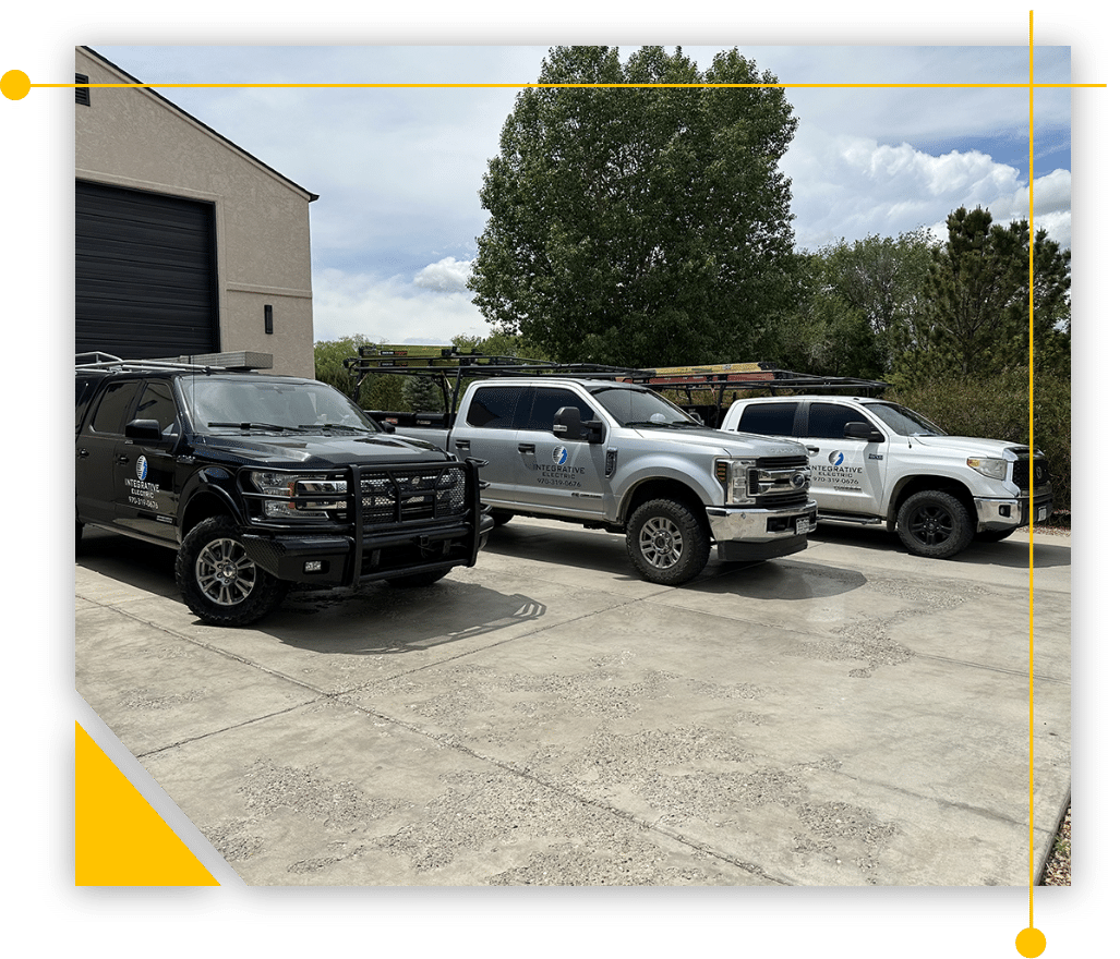 Three trucks are parked in a parking lot in front of a building.