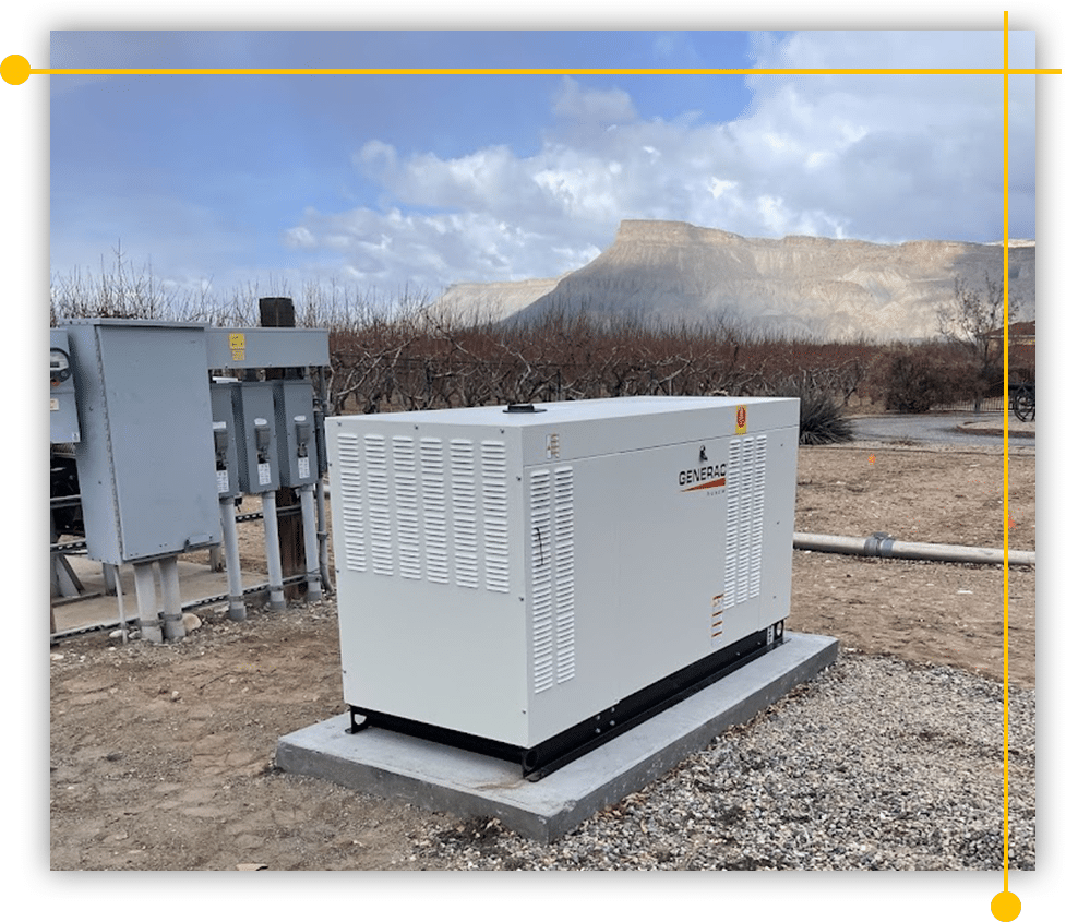 A large white generator is sitting in the middle of a dirt field.