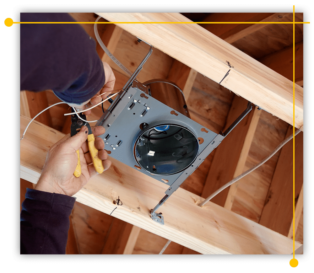 A person is working on a light fixture in the ceiling of a house.