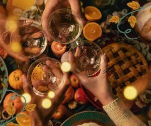 A group of people are toasting with wine glasses at a table.