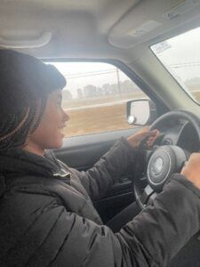 A woman is driving a car on a highway.
