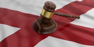 A wooden judge 's gavel is sitting on top of an england flag.