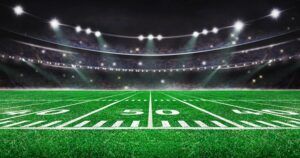 A football field with a stadium in the background.