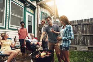 A group of people are having a barbecue in their backyard.