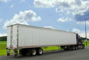 A semi truck is parked on the side of the road.