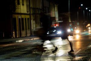 A blurry picture of a person walking down a street at night.