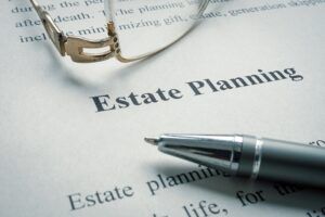 A pen is sitting on top of a piece of paper that says estate planning.