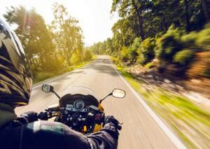 A person is riding a motorcycle down a road.
