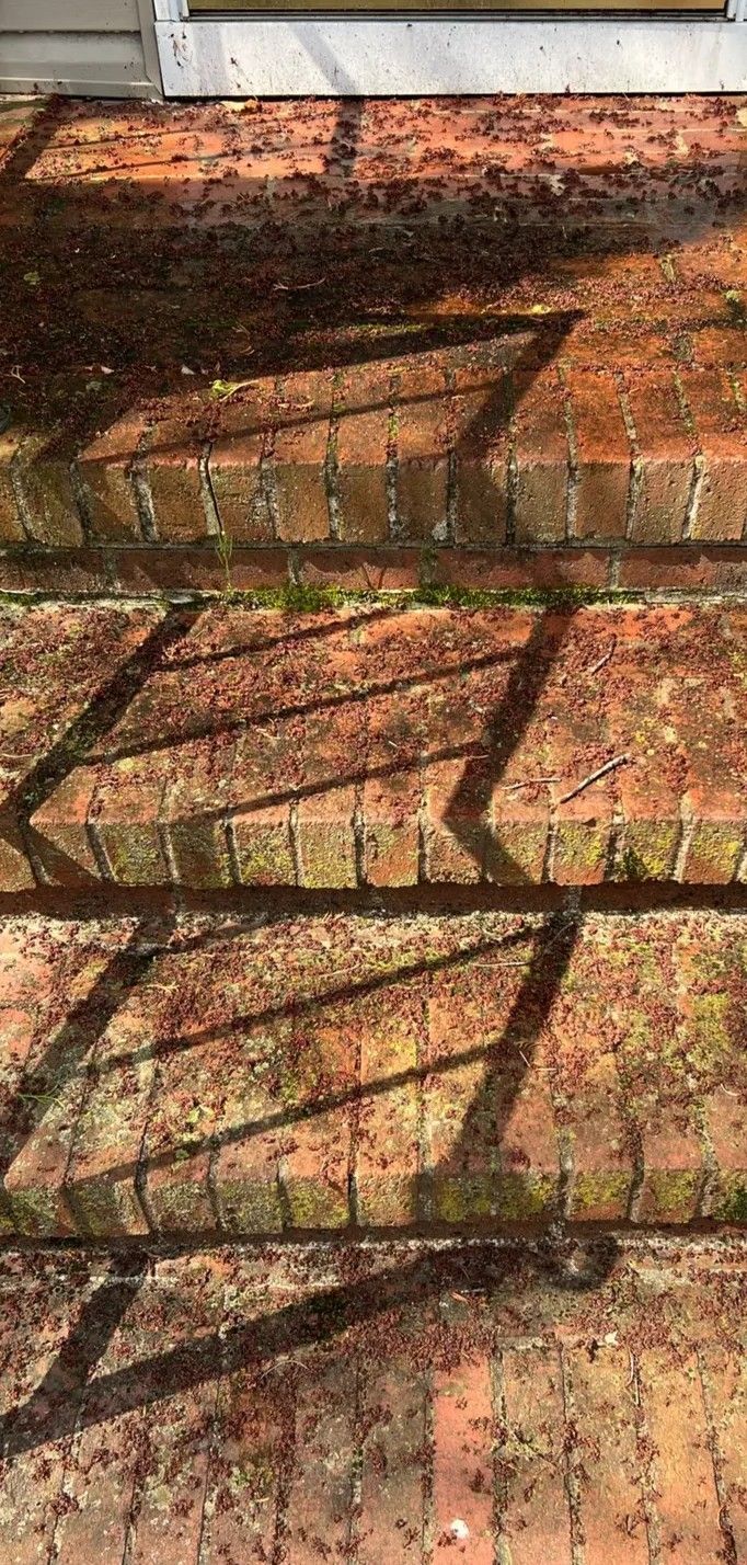 Sunlit brick wall with dark diagonal shadows and a white ledge at the top