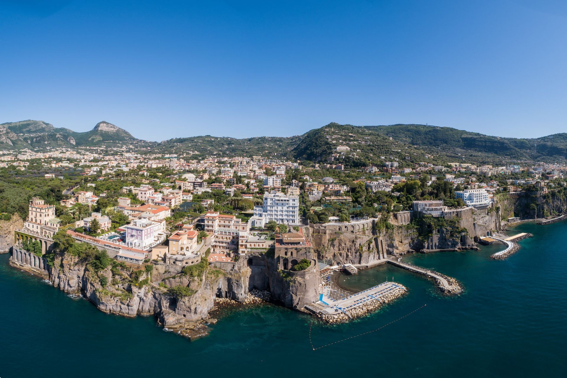 Veduta aerea della città costiera di Sorrento, in Italia, con i suoi edifici colorati arroccati sulle scogliere a picco sul mare.