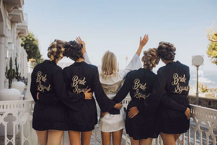 Five people stand in a row facing away, wearing matching black and white robes labeled 