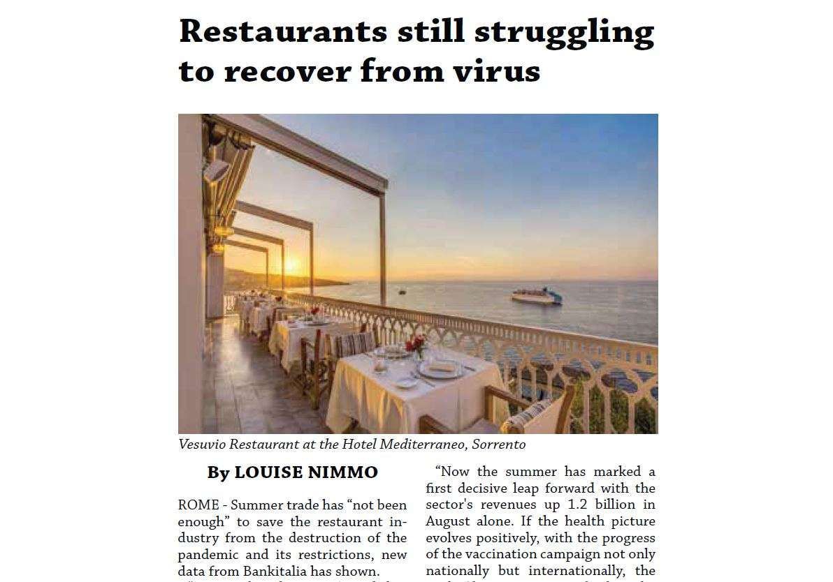 An outdoor restaurant terrace with white-clothed tables overlooking the sea at sunset, titled 