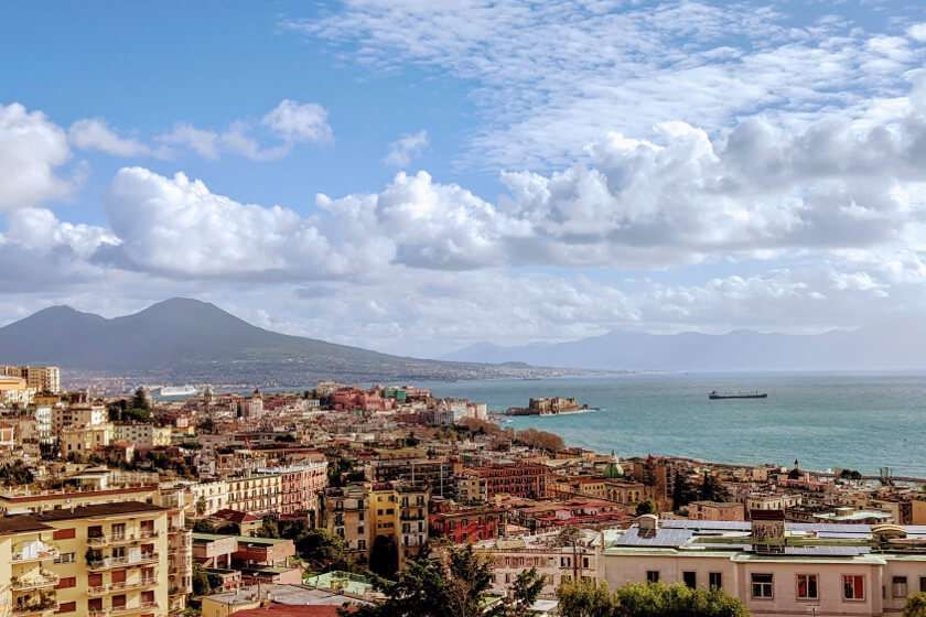 Veduta di Napoli, Italia, con il Vesuvio sullo sfondo, il paesaggio urbano costiero e il Mar Tirreno.