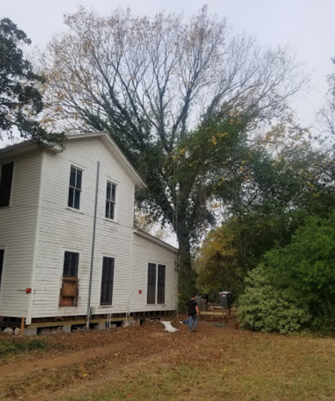A white house with a tree in front of it