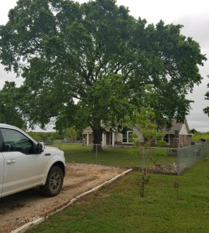 A white truck is parked in front of a house