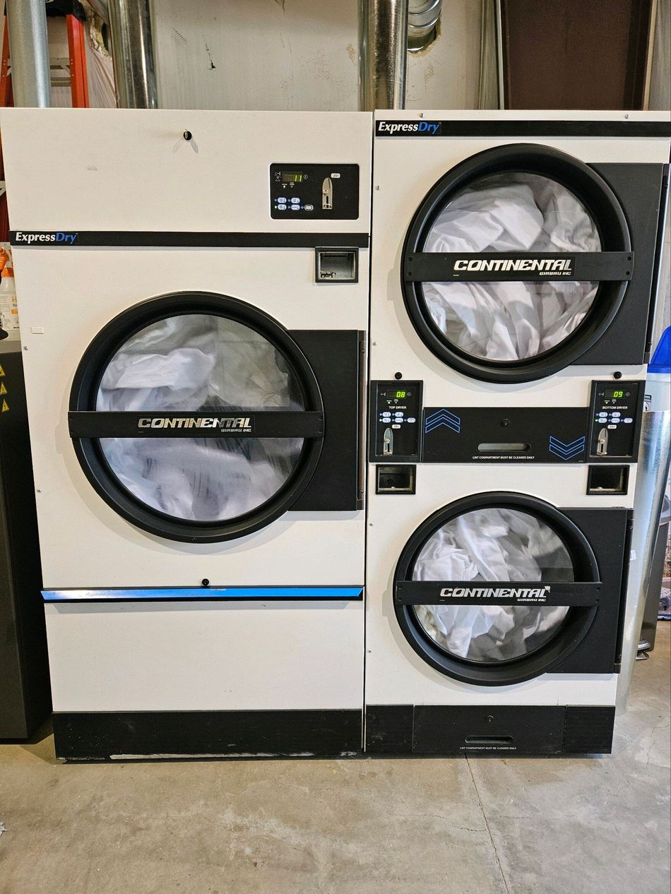 Three washers and dryers are stacked on top of each other in a laundromat.