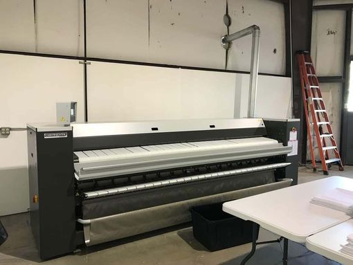A large machine is sitting in a room next to a table.