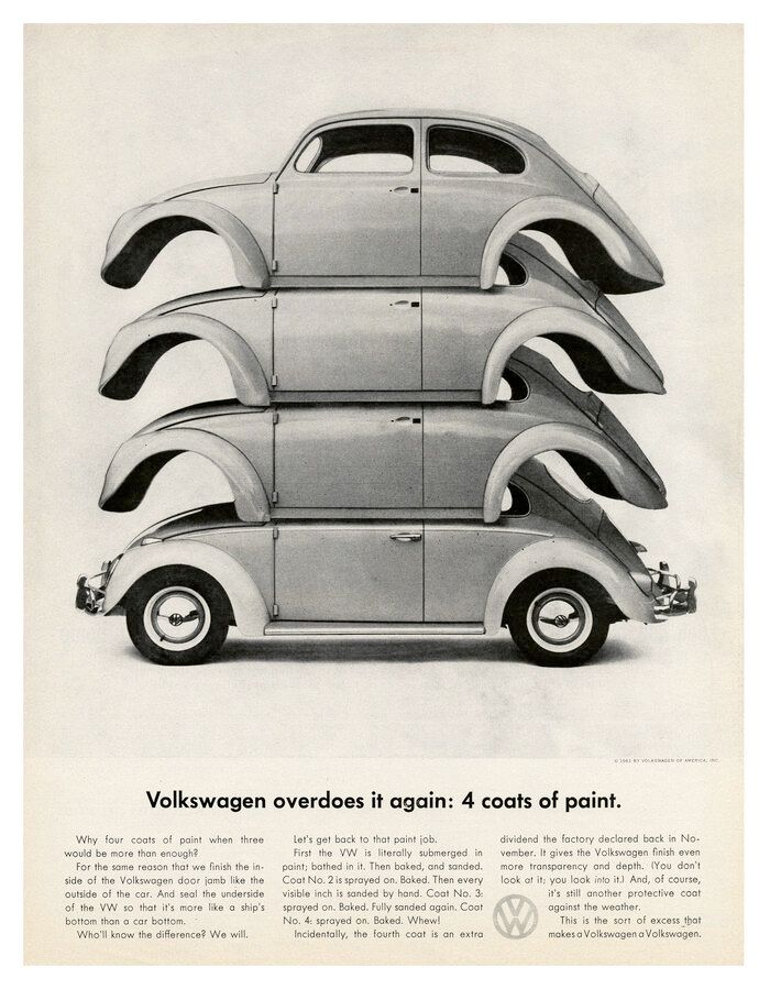 A black and white photo of a volkswagen beetle stacked on top of each other.