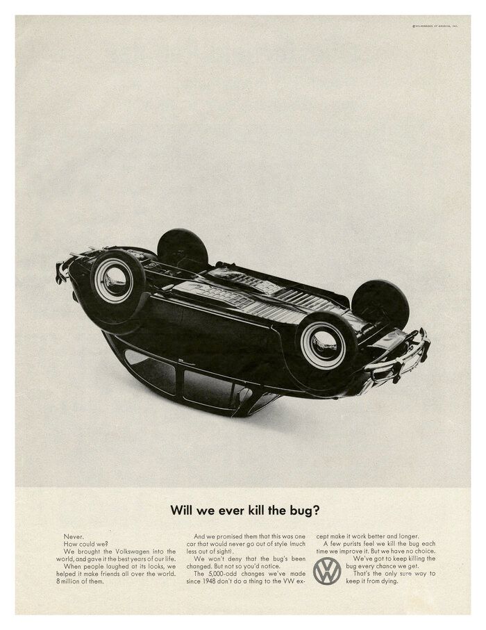 A black and white photo of a volkswagen car on its side.