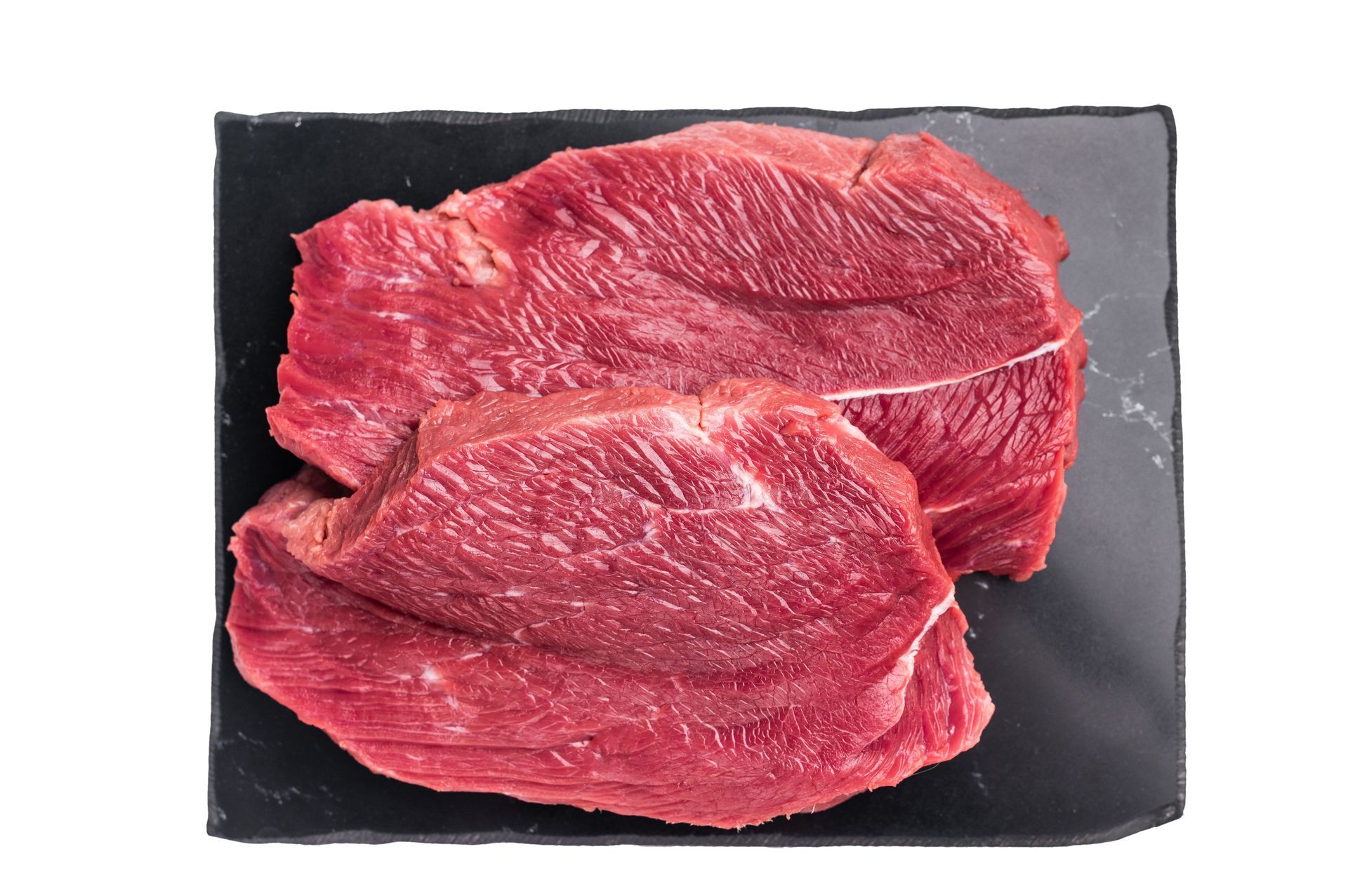 Two raw, red beef steaks on a black rectangular plate.