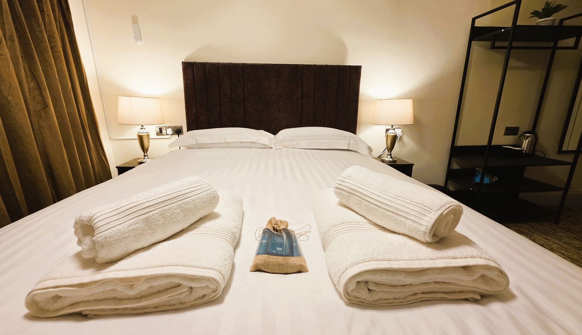 Hotel bedroom with a bed, lamps, and a window.