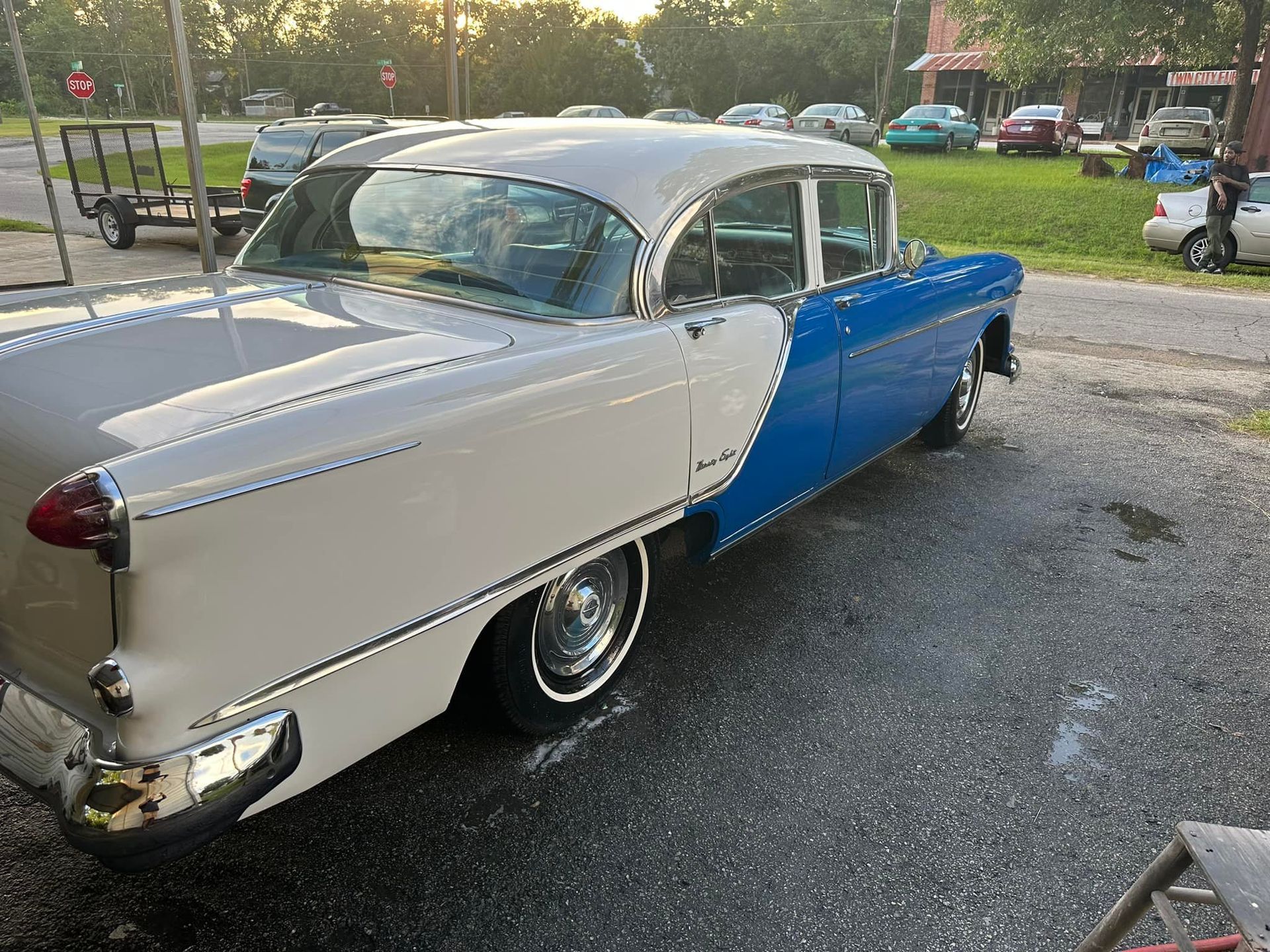 Classic blue and white car parked outside. Chrome details and whitewall tires are visible.