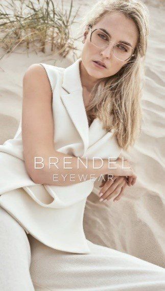 Frau im weißen Anzug und mit Brille auf Sand, BRENDEL Brillen.