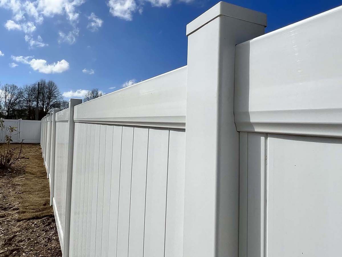 White vinyl privacy fence section, outdoor setting.