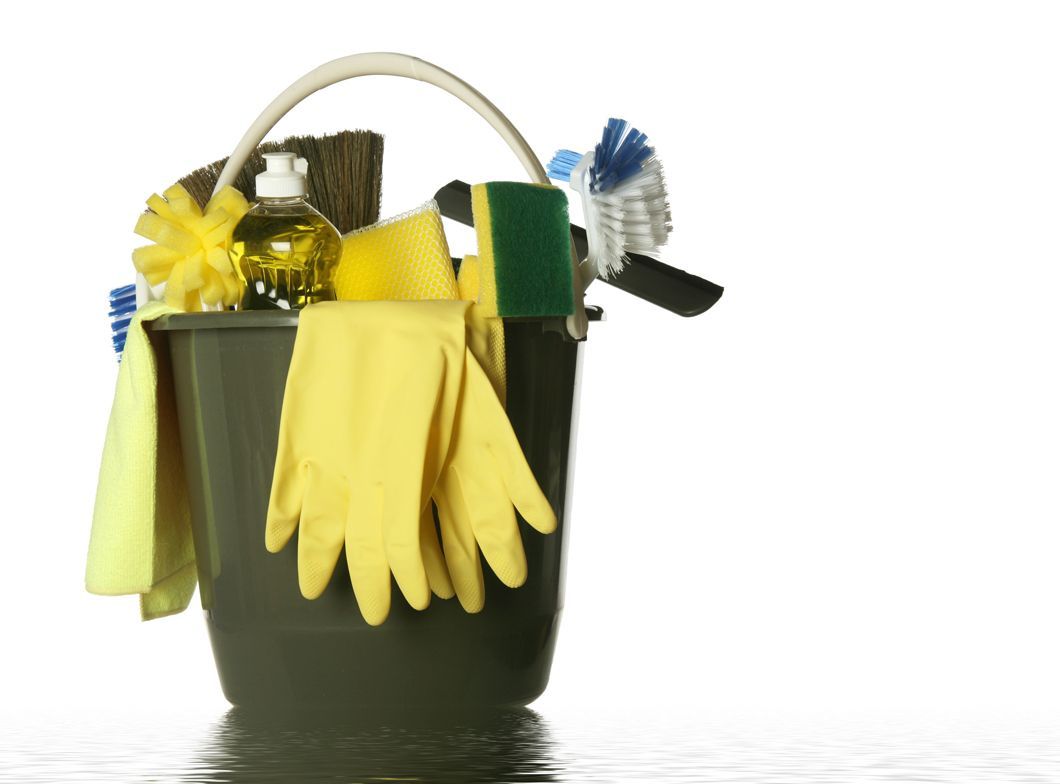 A black bucket filled with cleaning supplies including yellow gloves
