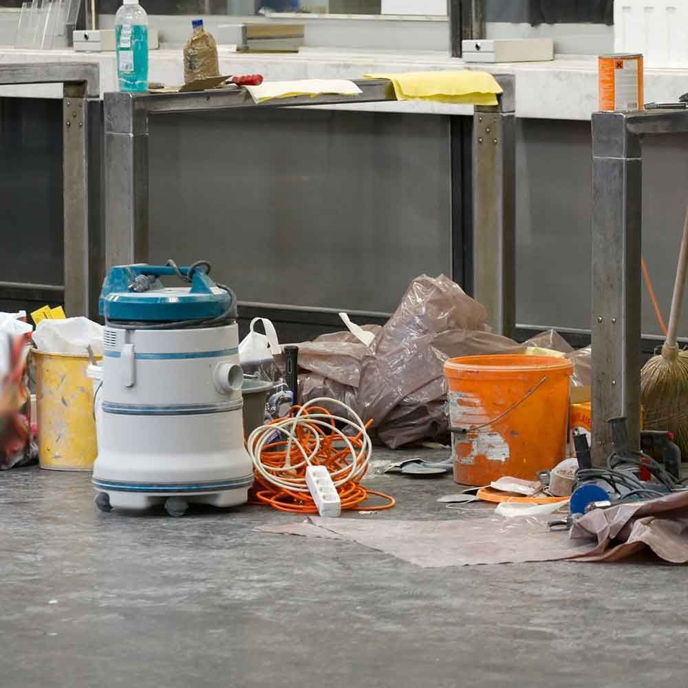 A vacuum cleaner is sitting on the floor next to a bucket