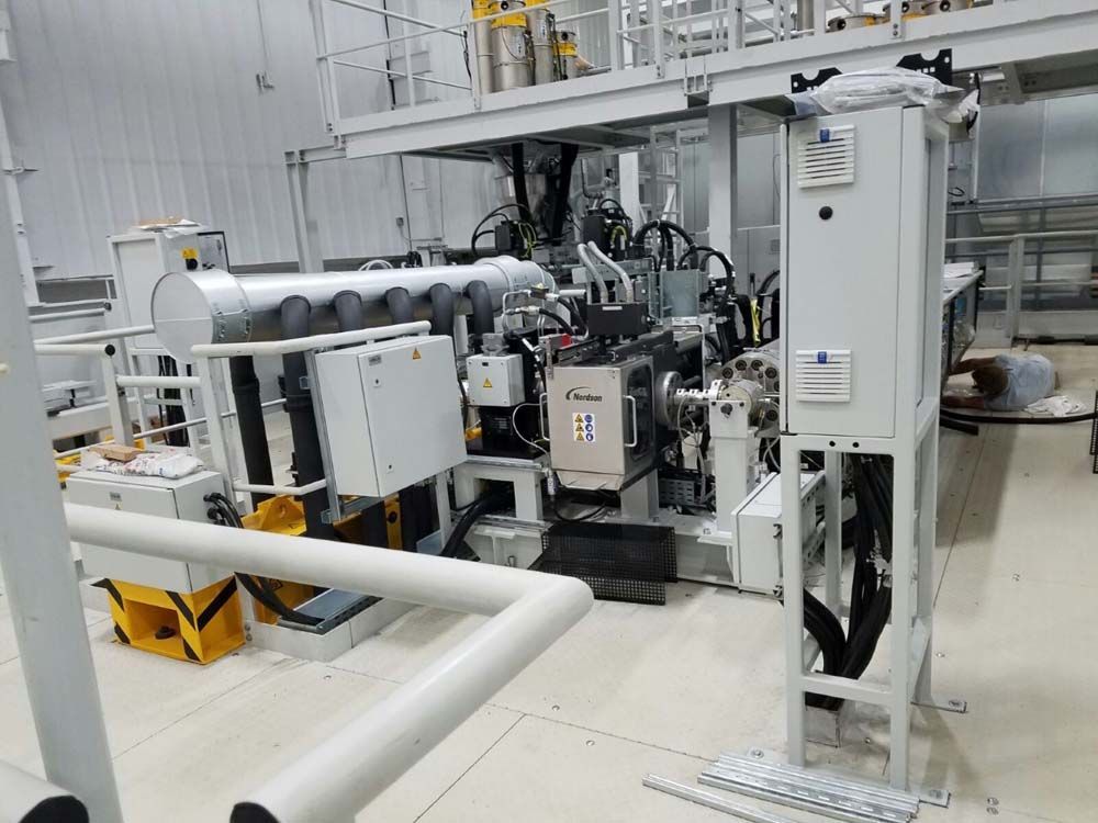 A large machine is sitting in a room in a factory.