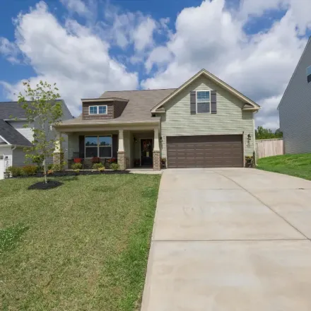 a concrete driveway in Denver with a smooth finish and a brown garage door with a beige home
