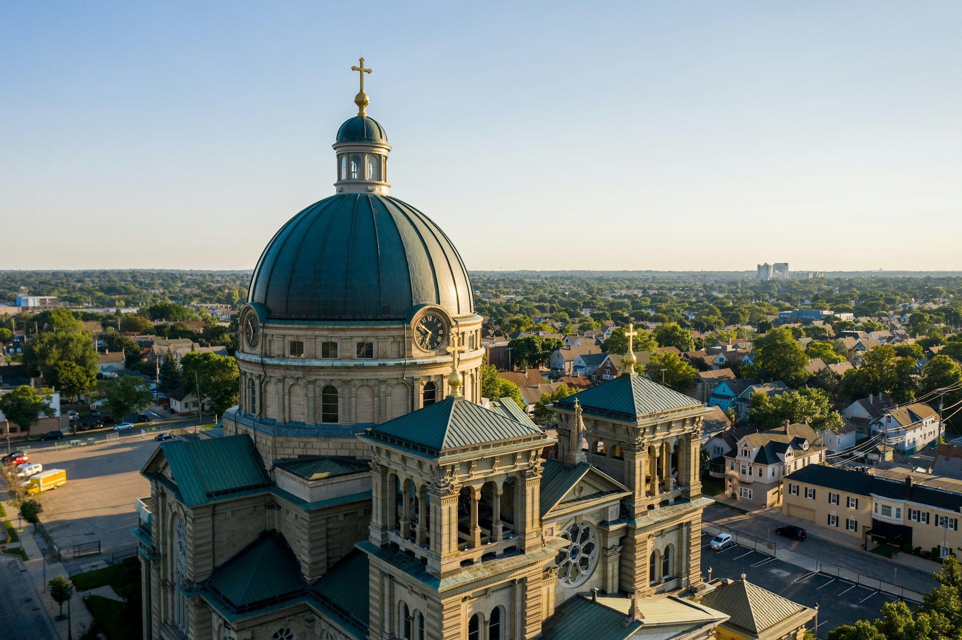 Aerial view of a large church with a teal dome and multiple steeples, surrounded by a residential area.