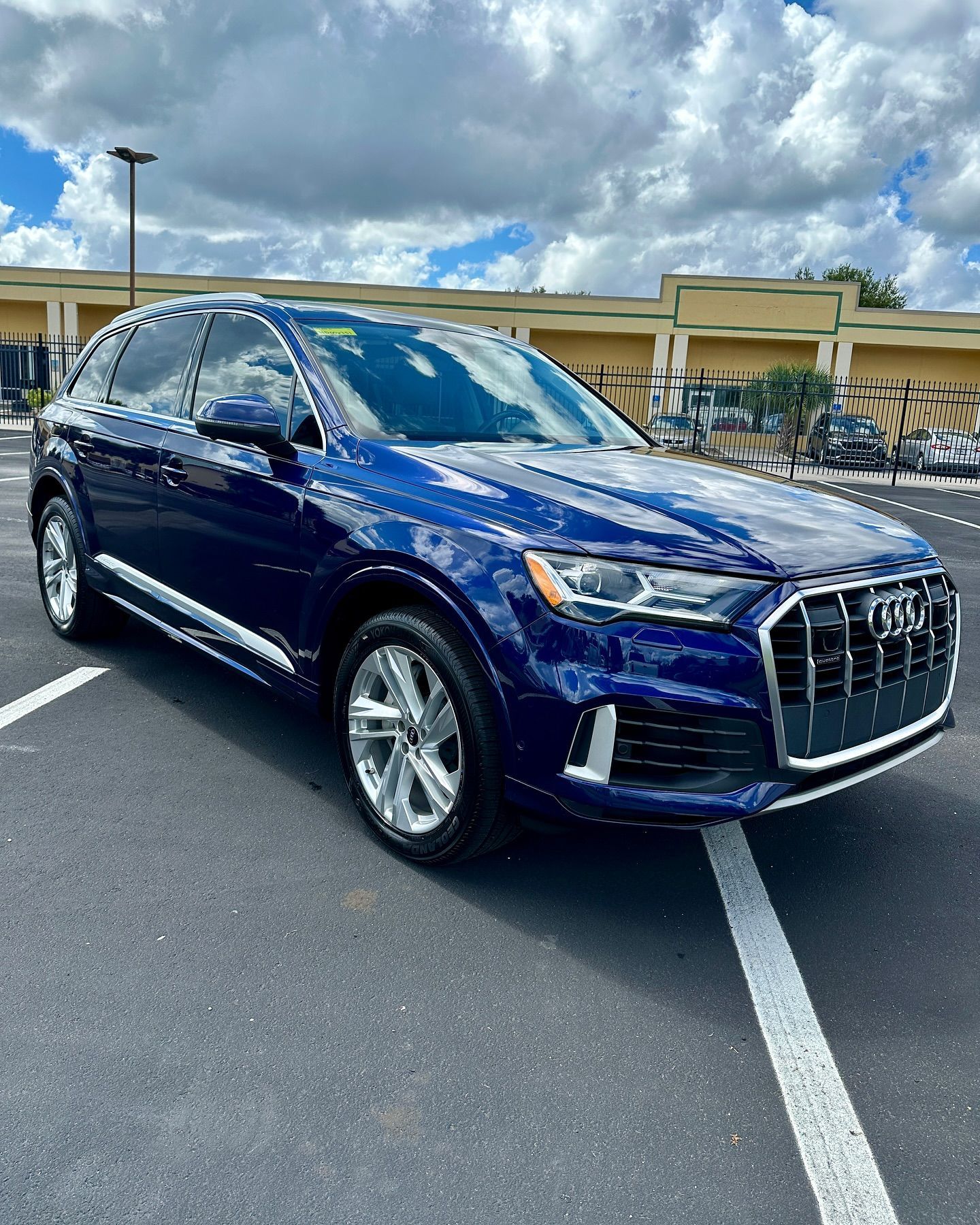 A blue audi q7 is parked in a parking lot.
