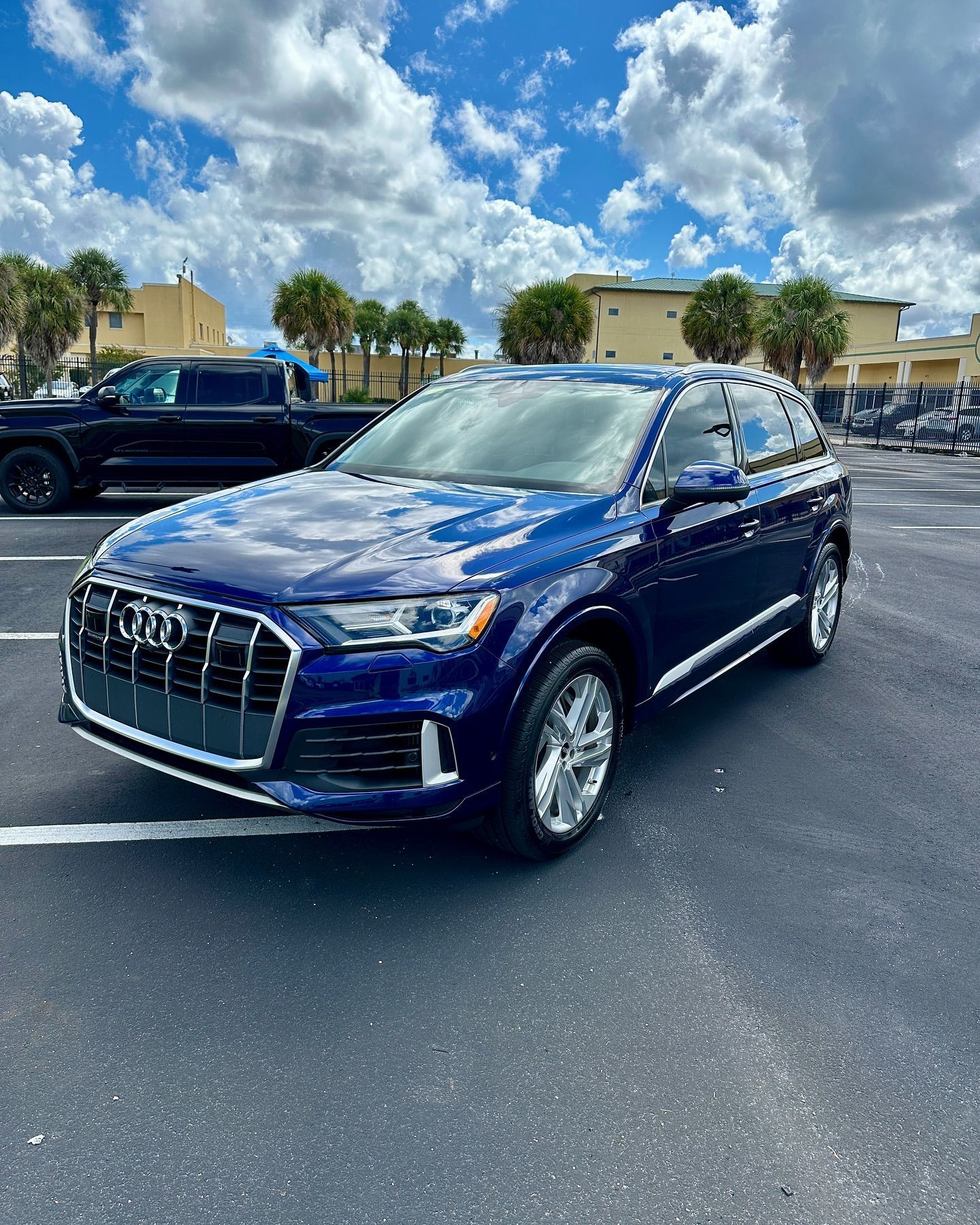 A blue audi q7 is parked in a parking lot.