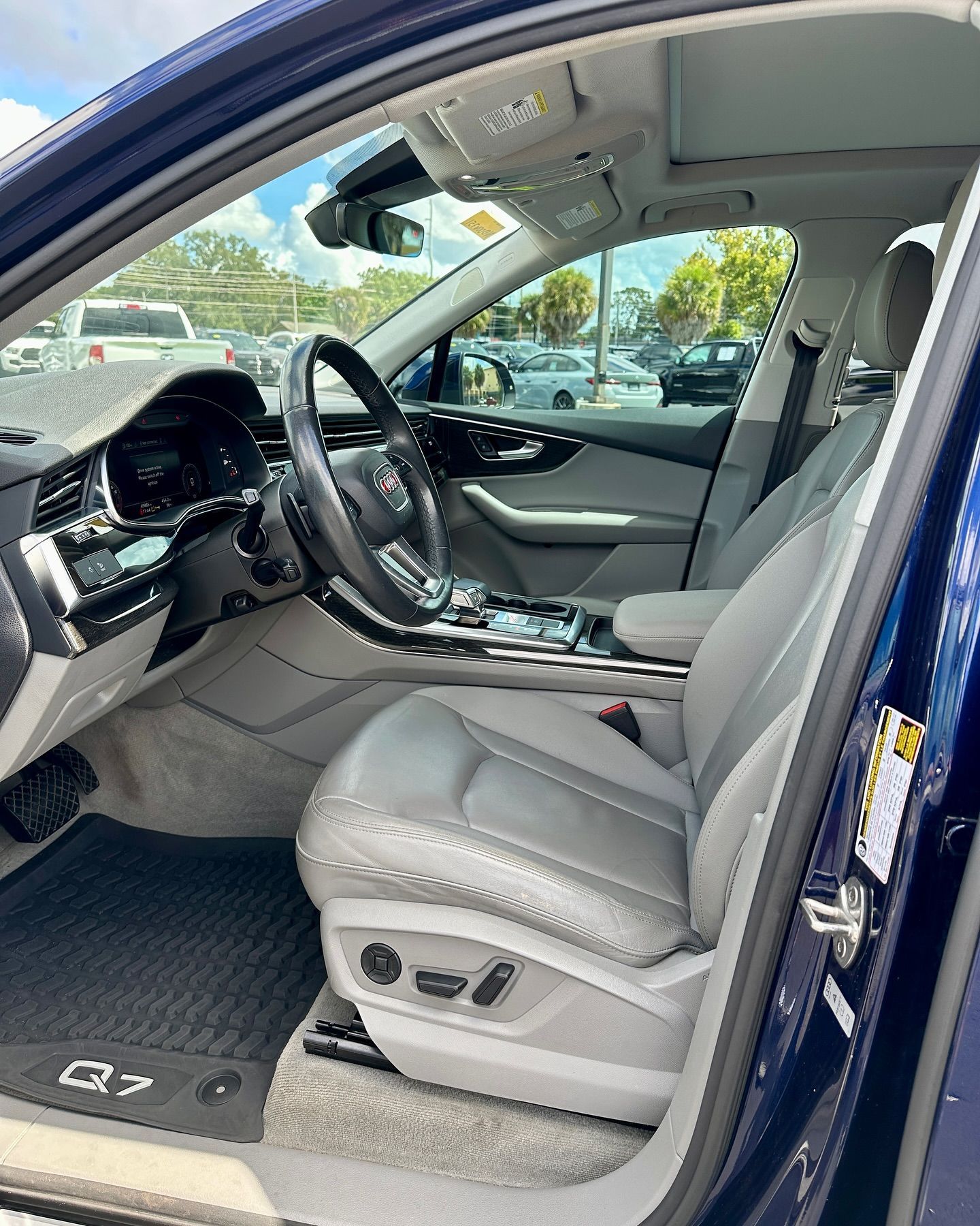 The interior of a blue audi q7 is shown with the door open.