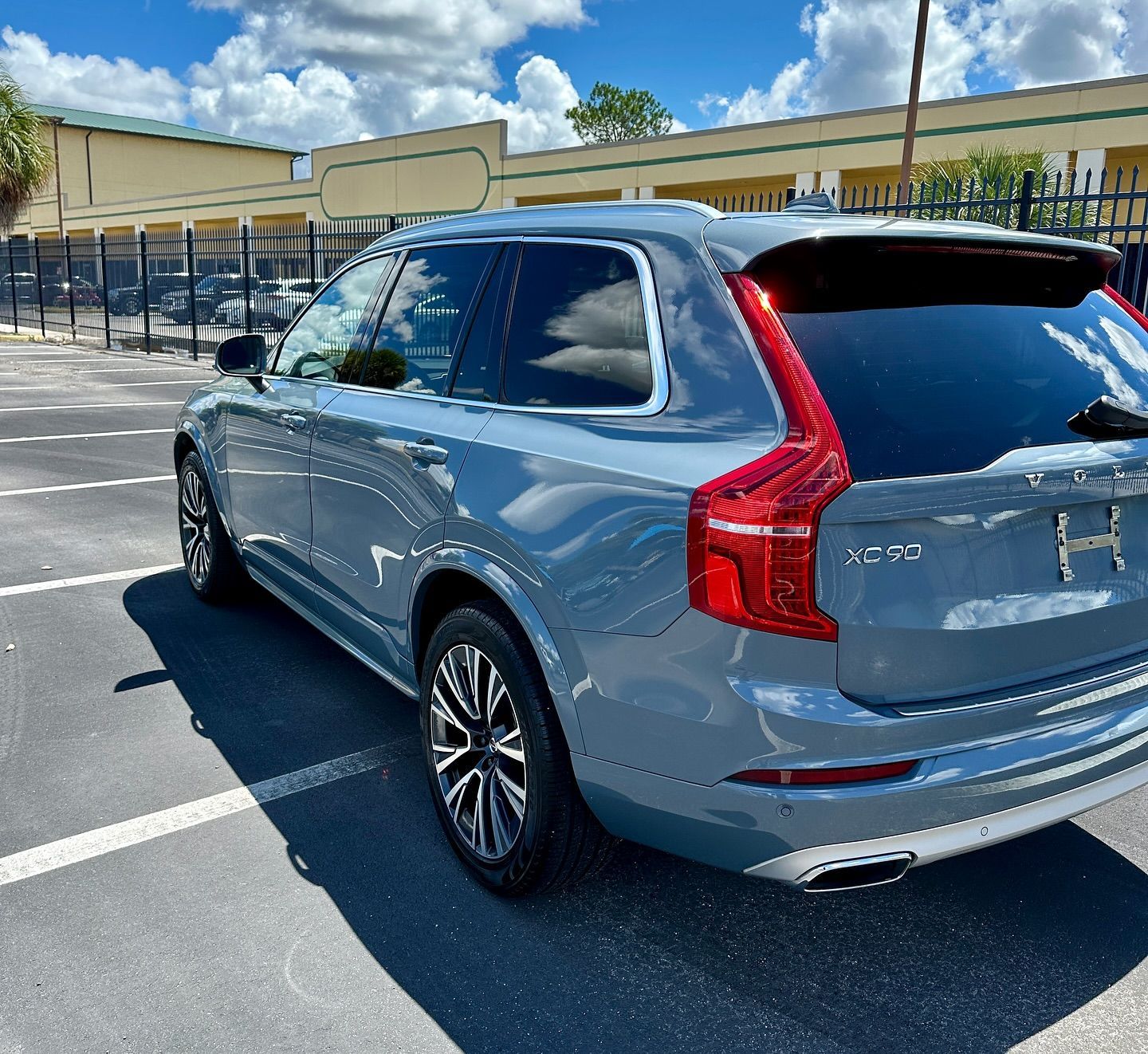 A silver volvo xc90 is parked in a parking lot