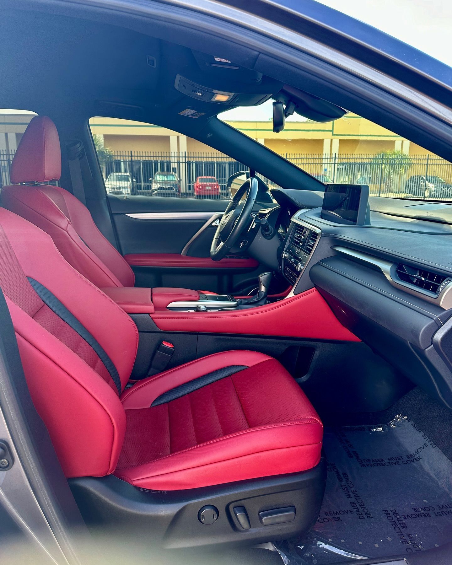 The inside of a car with red seats and a steering wheel.
