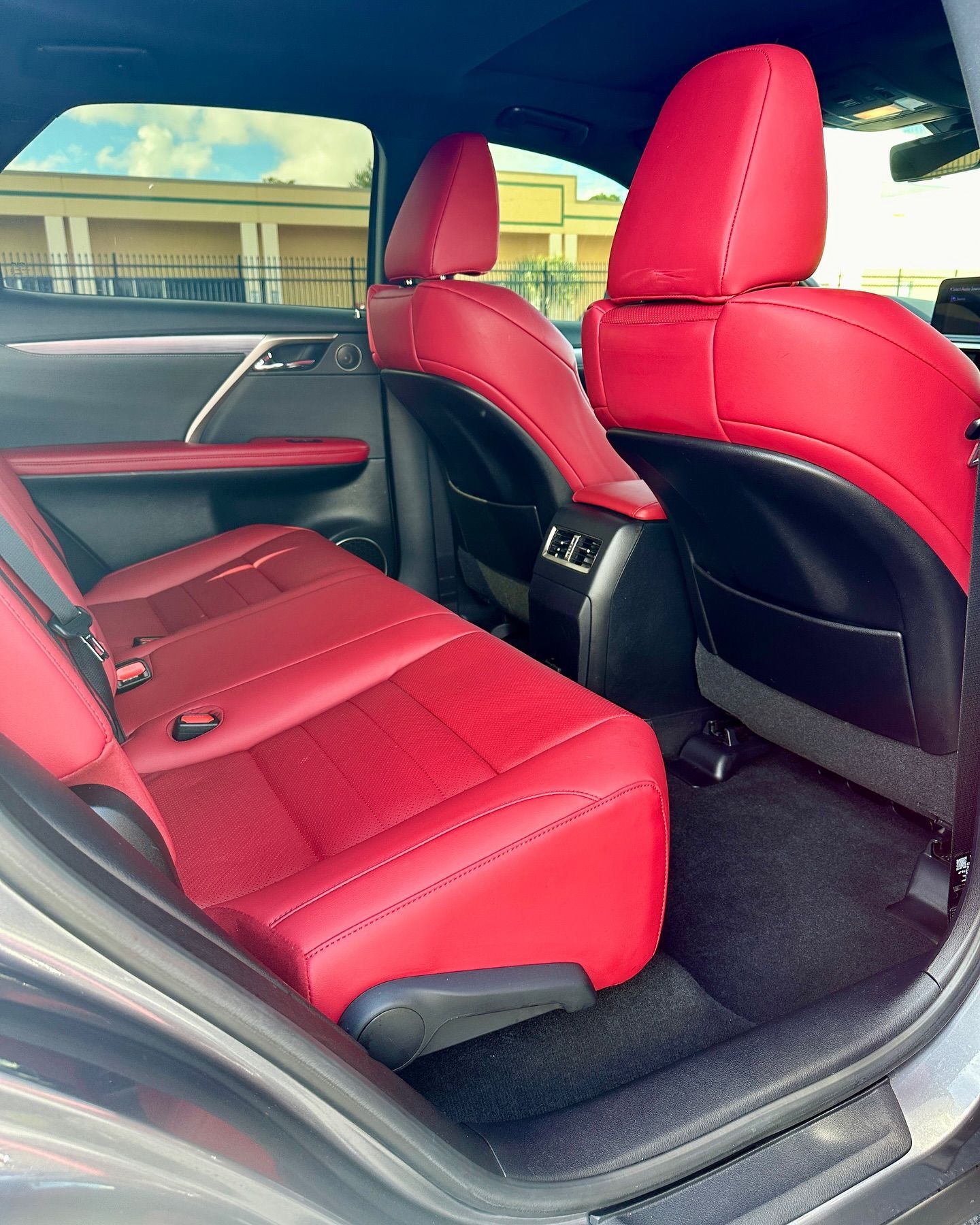 The back seat of a car with red seats