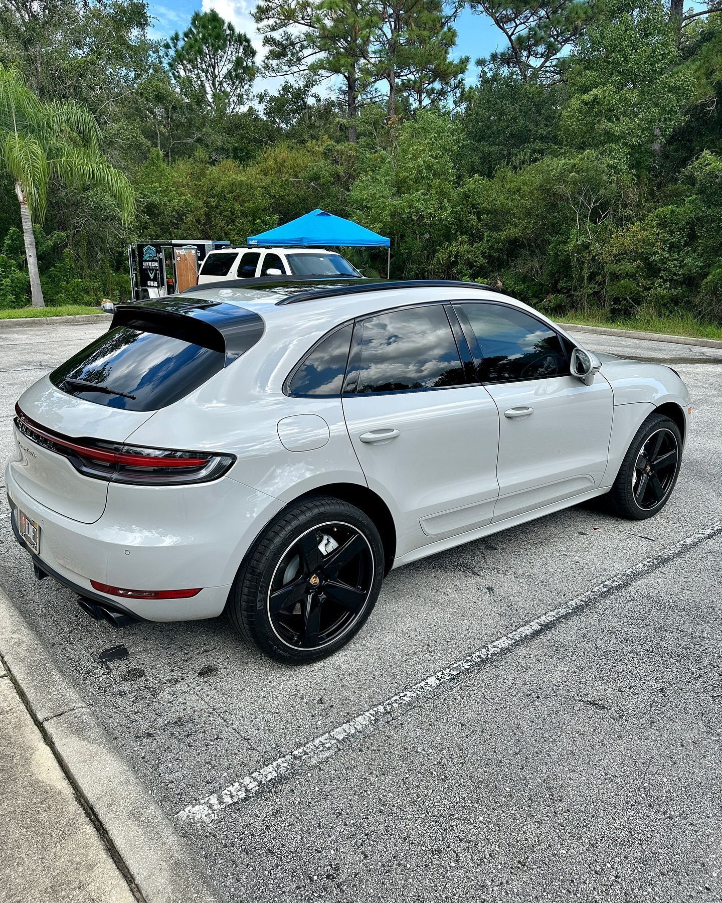 A white porsche macan turbo is parked in a parking lot.