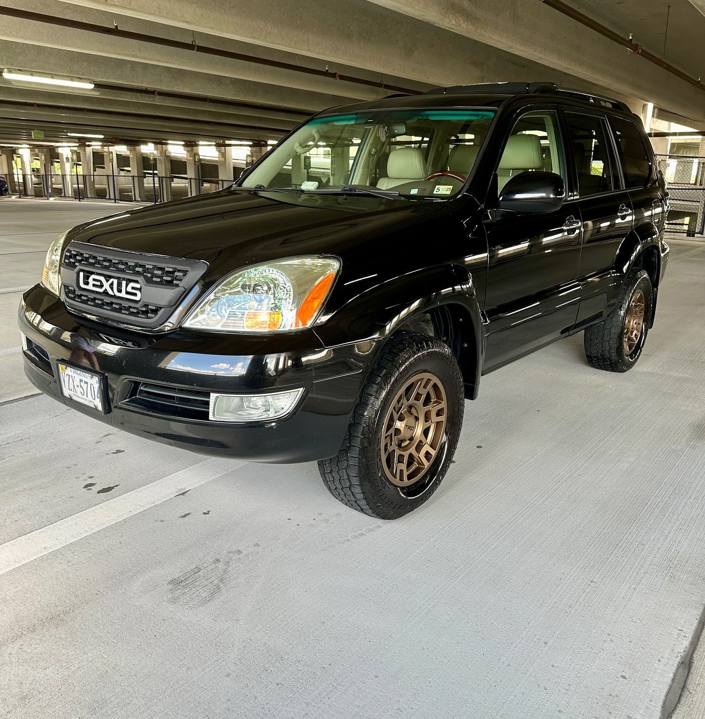 A black lexus suv is parked in a parking garage.
