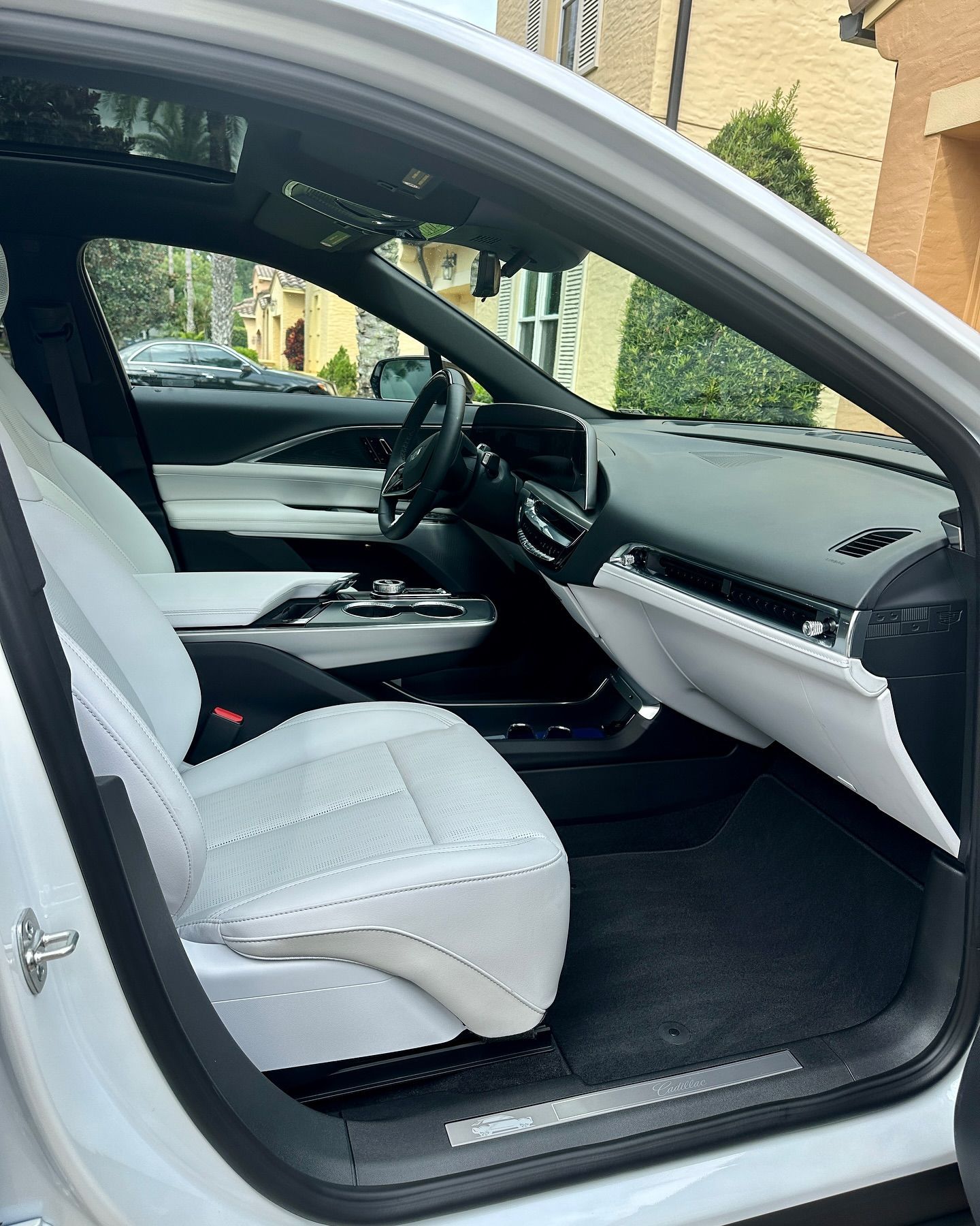 The interior of a white car with the door open.
