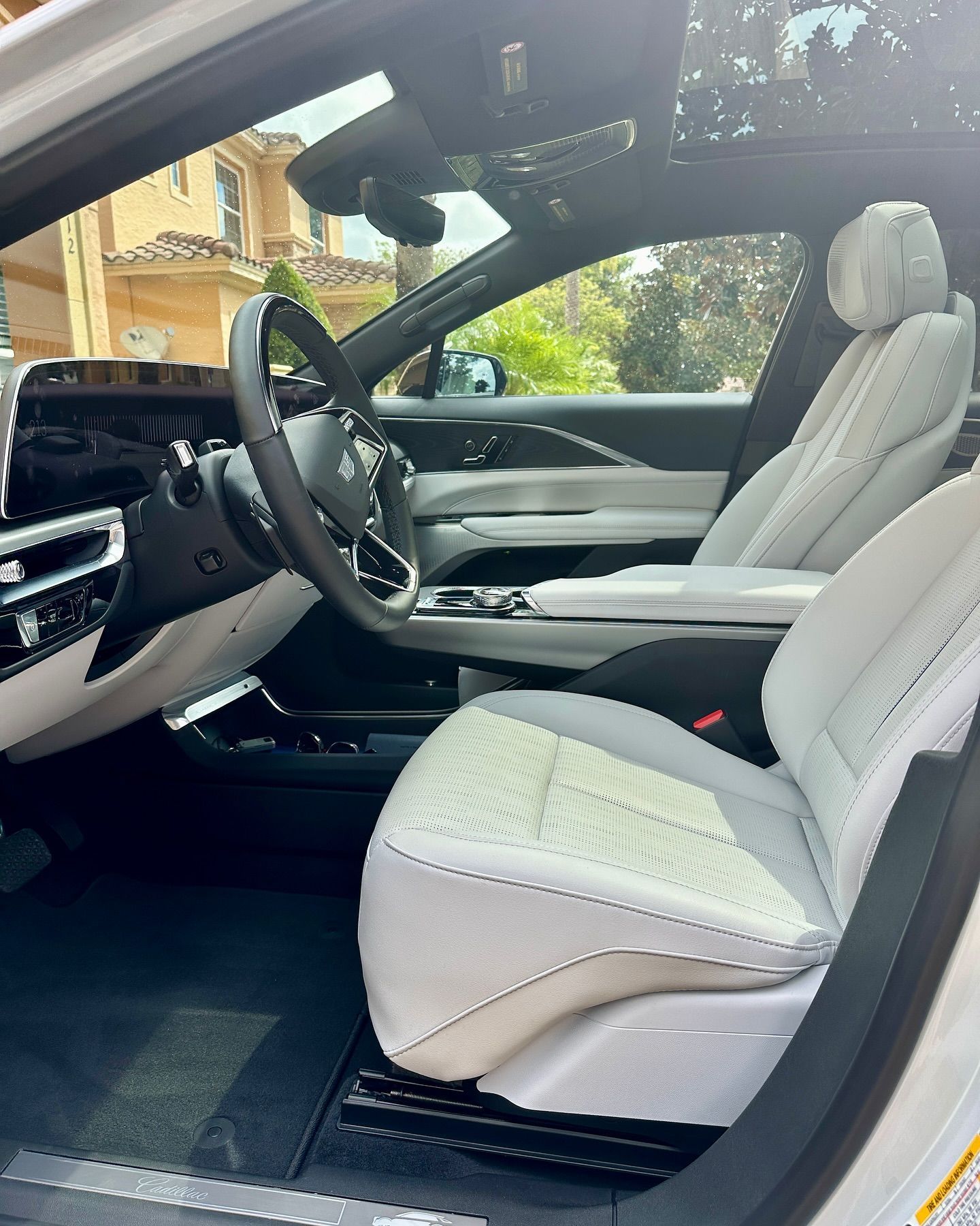 The interior of a white car with white seats and a steering wheel.